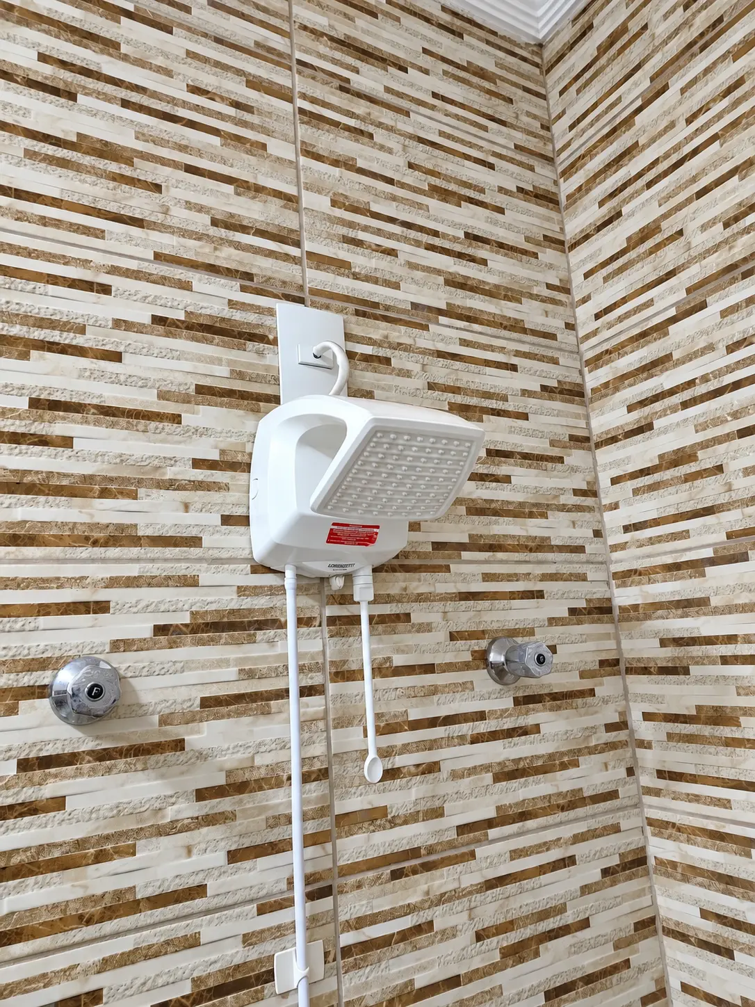 Chuveiro elétrico instalado em parede revestida